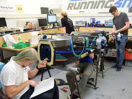 Studierende arbeiten an einem Rennwagen in der Motorsport Werkstatt